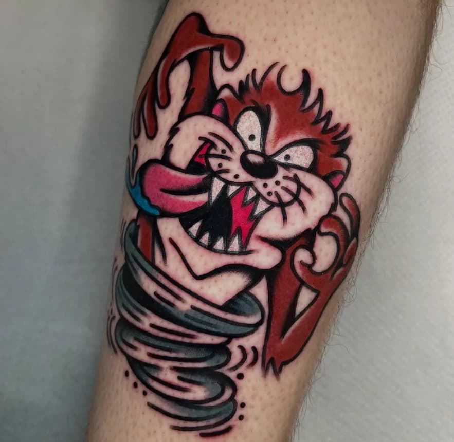 Traditional tattoo of Taz the Tasmanian Devil spinning in a tornado, on the forearm